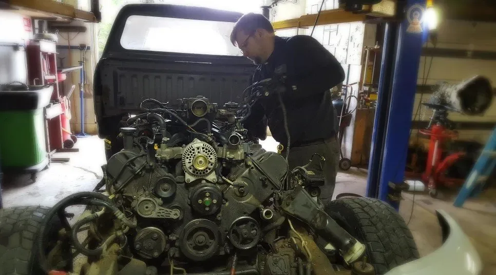 An Advanced Autometric technician working on an exposed engine in the shop